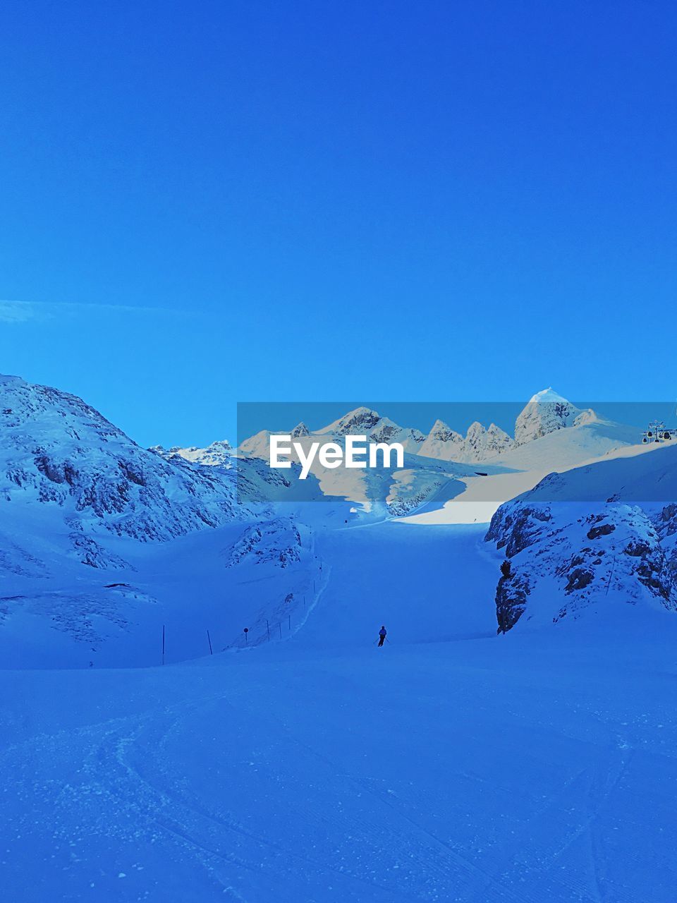 Scenic view of snowcapped mountains against clear blue sky