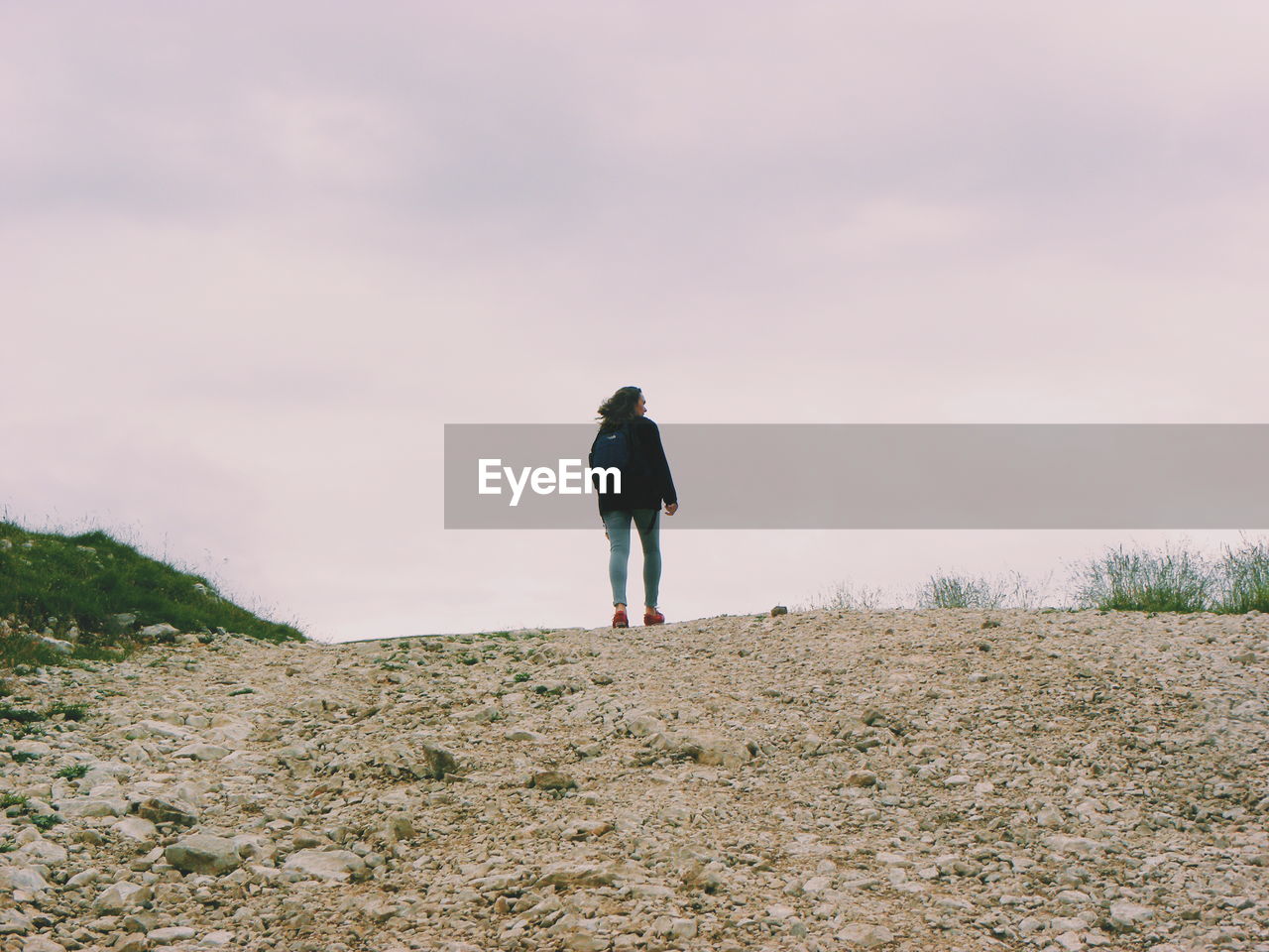 Rear view of woman standing on landscape against sky