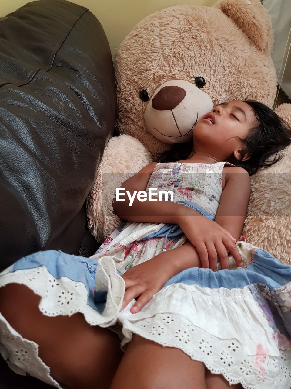 High angle view of girl lying on sofa at home