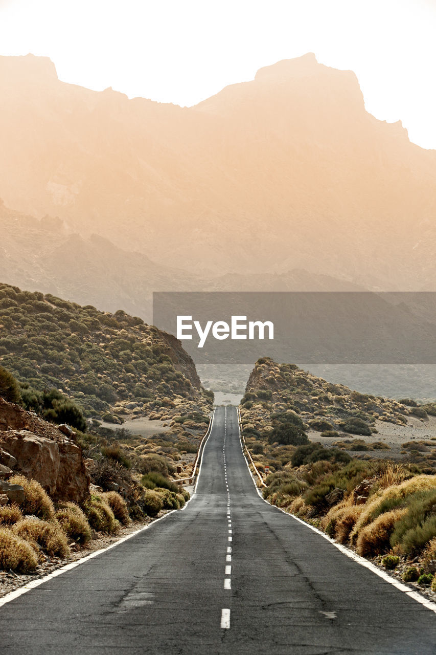 Empty road leading towards mountains