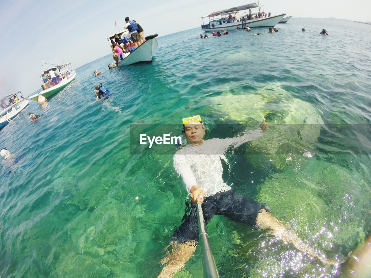 Fish-eye lens shot of man swimming in sea