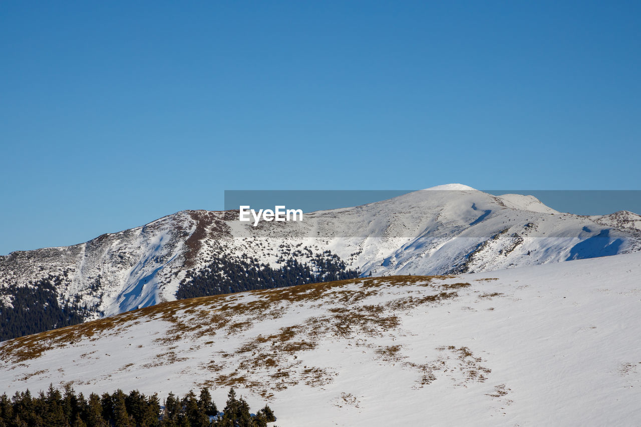 SNOWCAPPED MOUNTAIN AGAINST CLEAR BLUE SKY