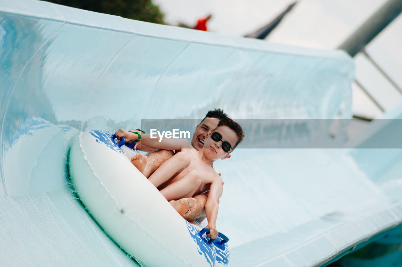 Cheerful father and son enjoying at water park