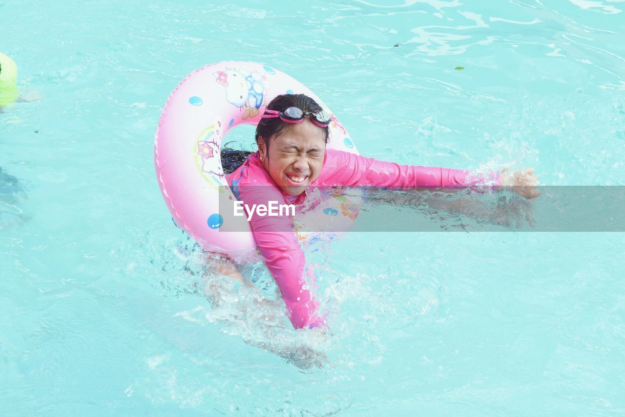 Girl with inflatable ring swimming in pool
