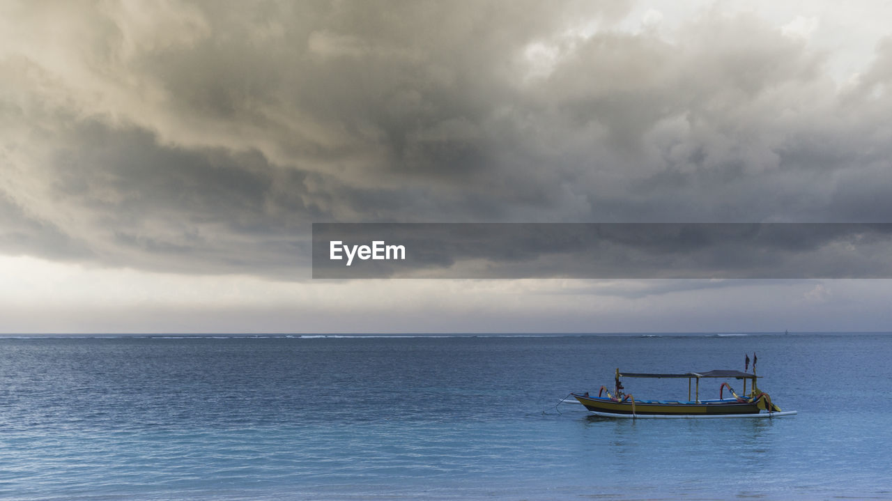 BOAT IN SEA AGAINST SKY