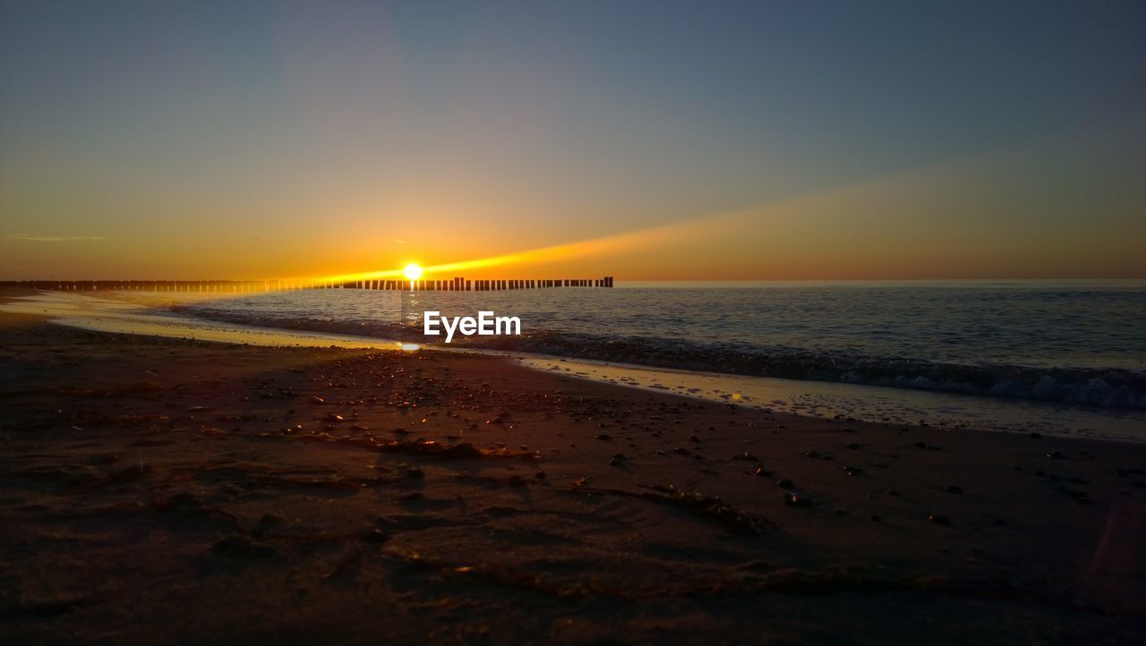 SCENIC VIEW OF SEA AGAINST SKY AT SUNSET