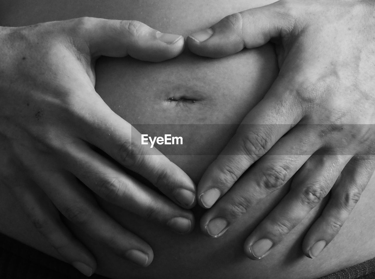 Cropped hands of pregnant woman touching abdomen