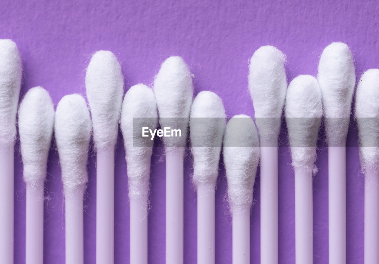 Close-up of cotton swabs arranged on blue table