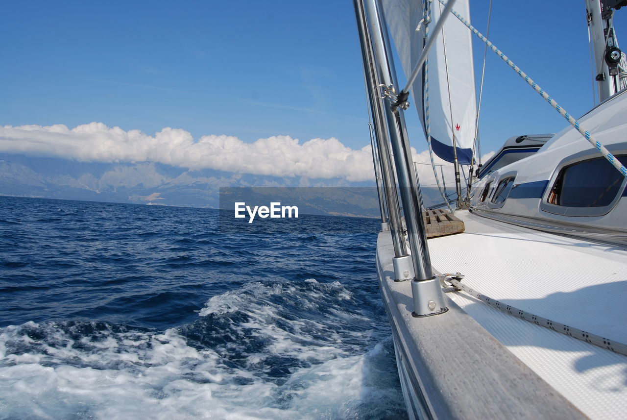 Sailboat sailing on sea against sky