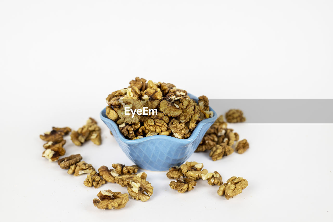 Walnuts in a bowl drawn in front of a white background