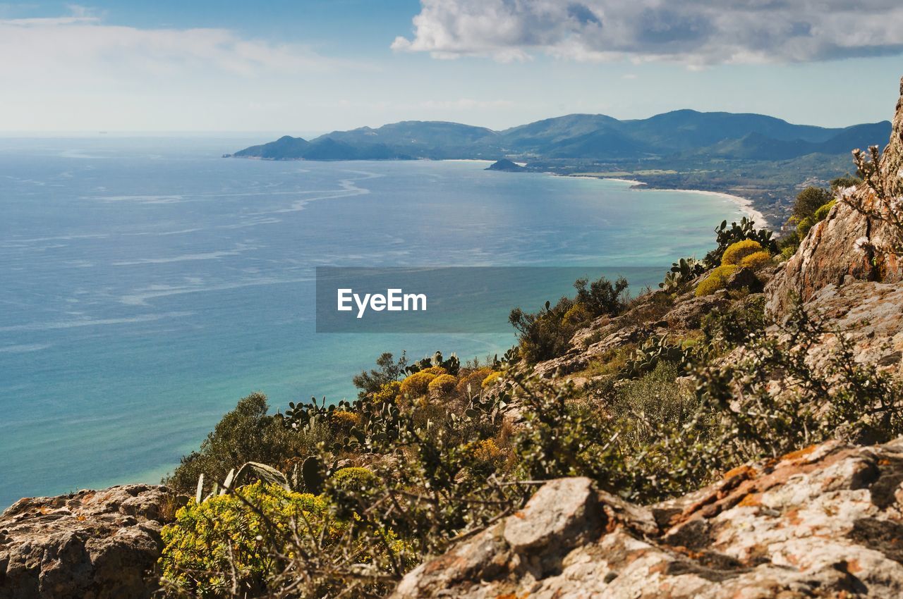 Scenic view of sea and mountains against sky