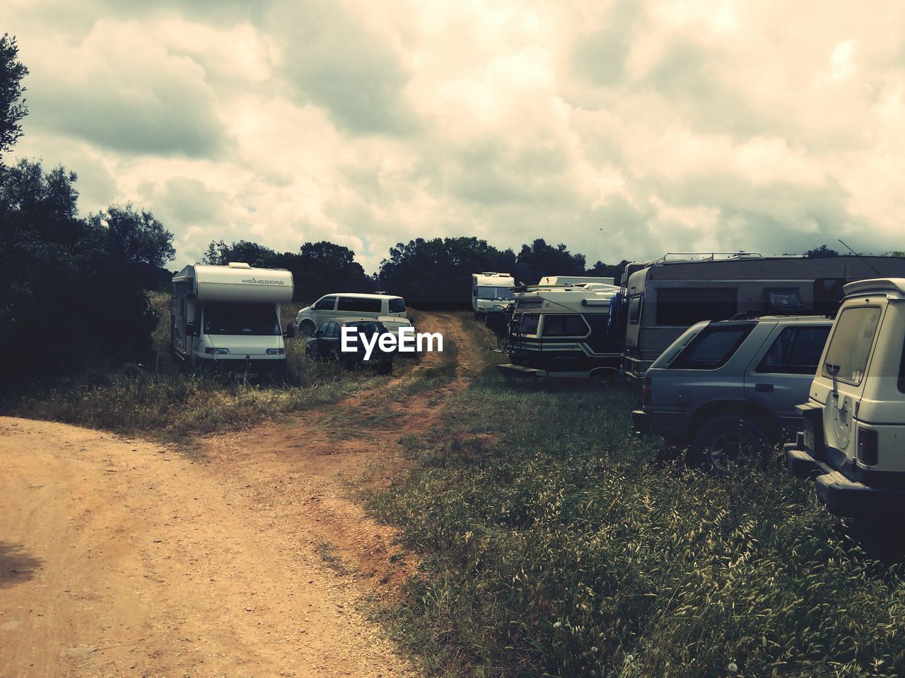 Cars on road amidst field against sky