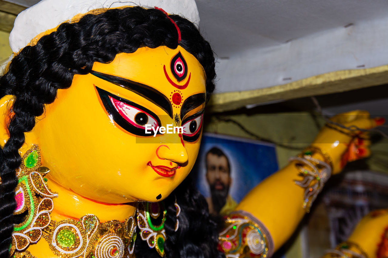 Close-up of yellow durga statue