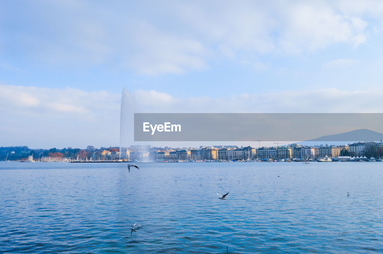 SEA BY BUILDINGS AGAINST SKY