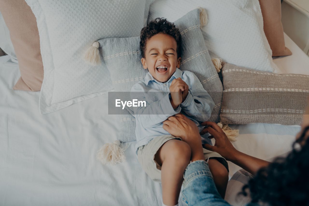 High angle view of baby lying on bed