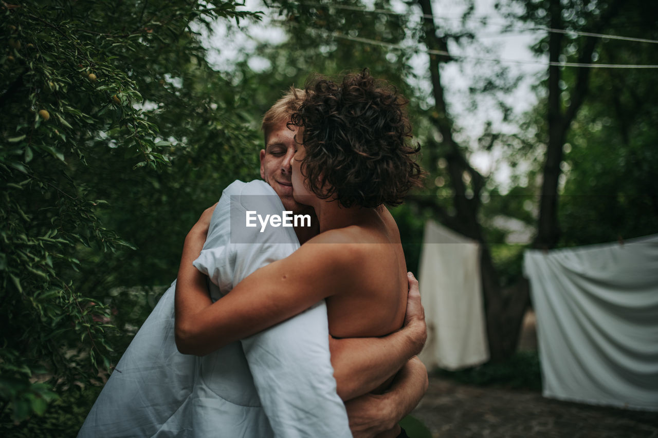 Couple standing against trees