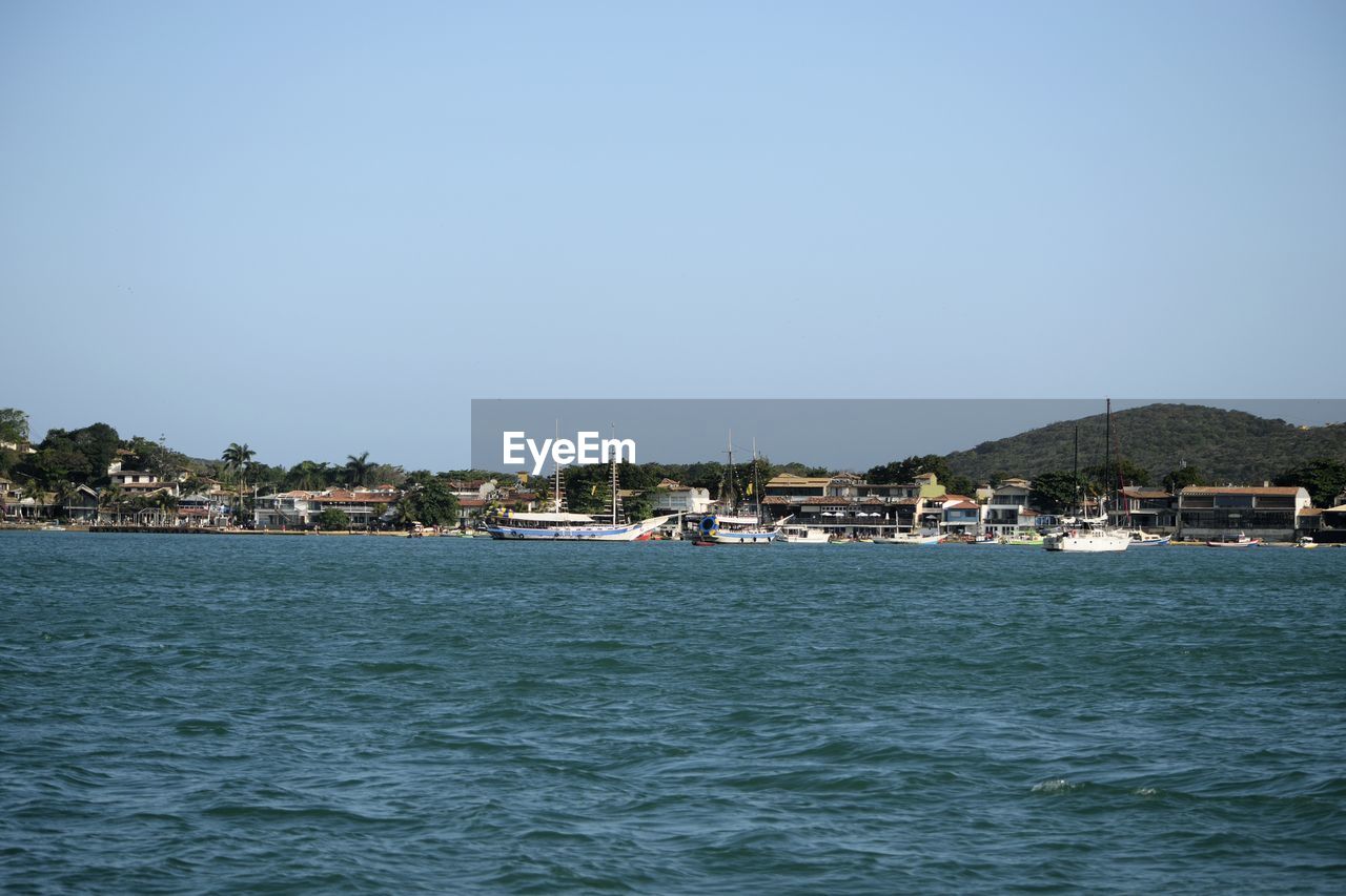 SCENIC VIEW OF SEA AGAINST BUILDINGS IN CITY