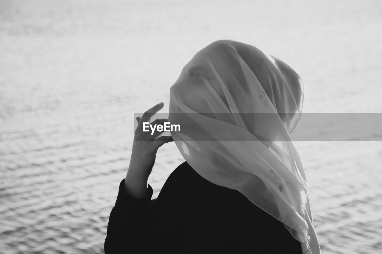 Close up of woman with covered face by lake