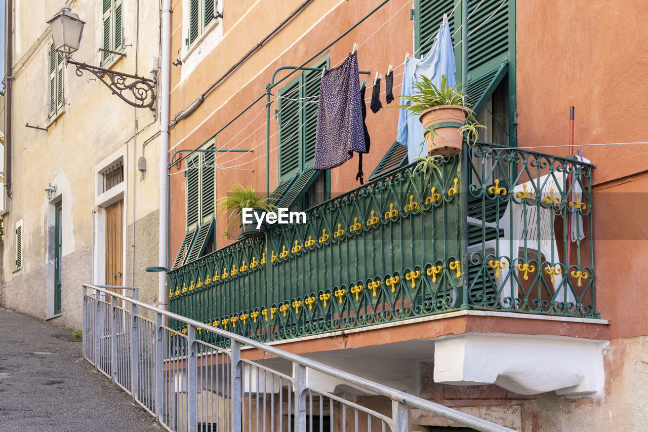 architecture, building exterior, balcony, built structure, city, wall, building, railing, facade, residential district, road, street, urban area, handrail, neighbourhood, no people, house, window, iron, day, staircase, outdoors, stairs, nature, baluster