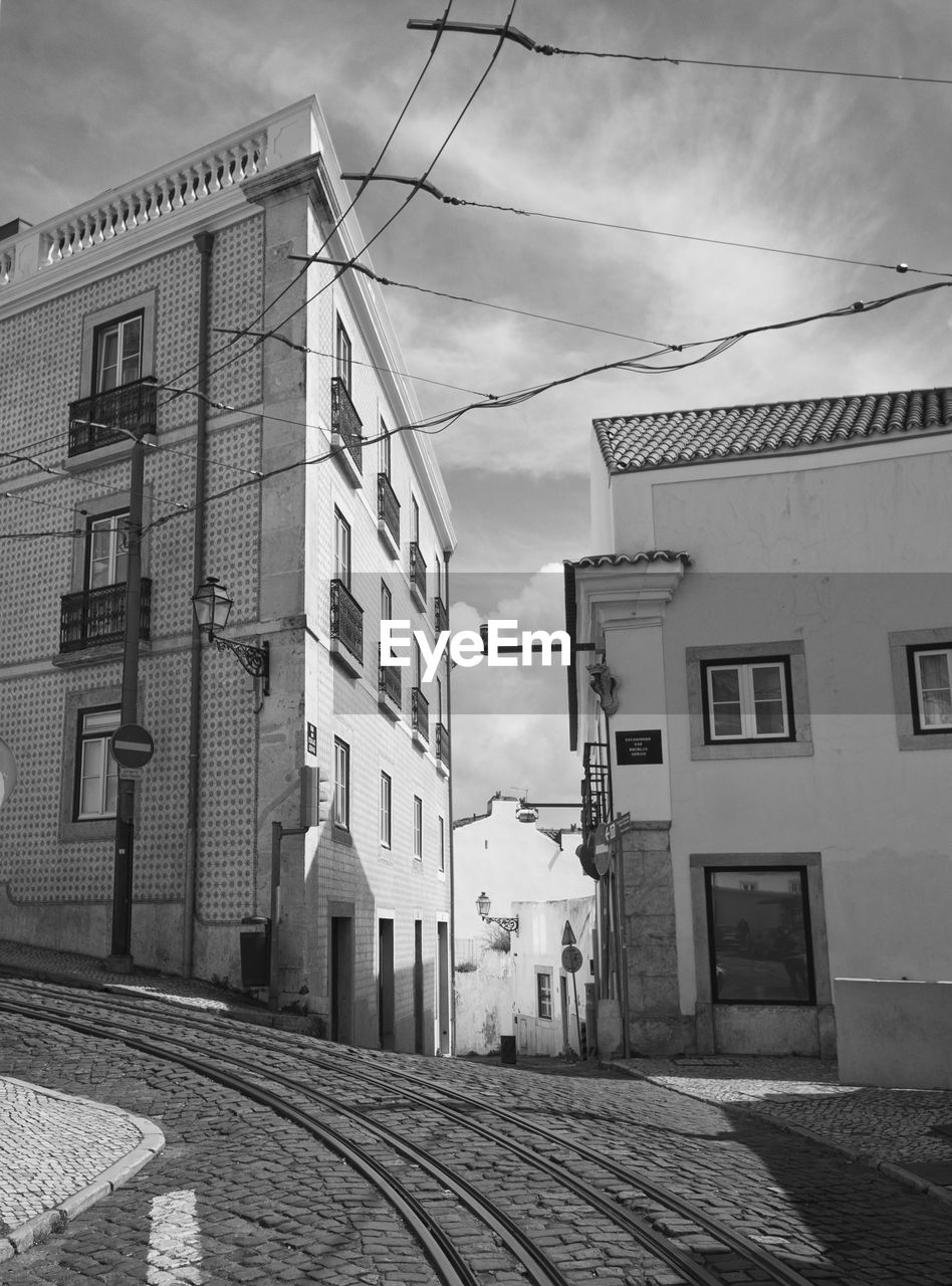 Street amidst buildings in town against sky