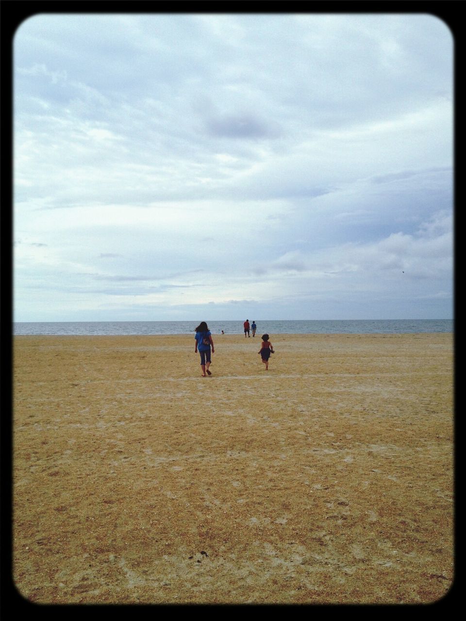 Group of people walking along sandy beach