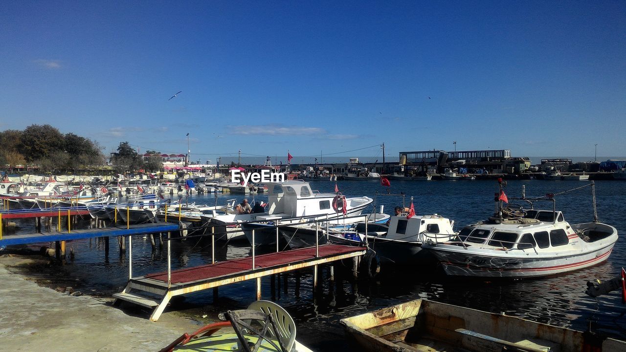 BOATS MOORED AT HARBOR