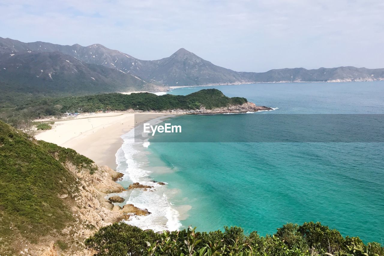 Scenic view of sea and mountains against sky