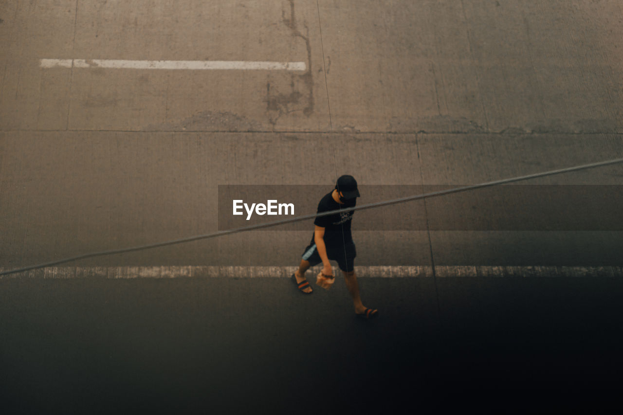 High angle view of man walking on road 