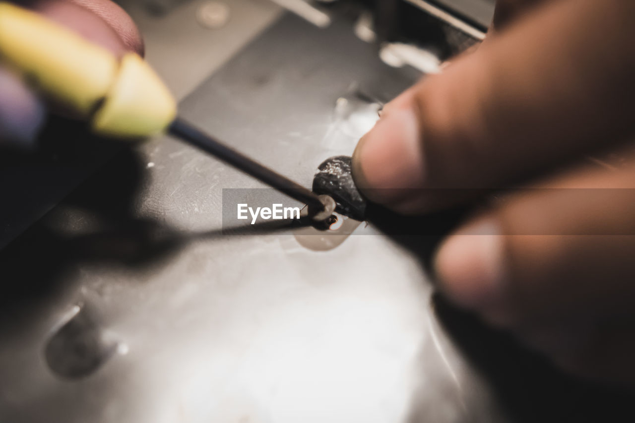 Cropped hand fixing equipment at workshop