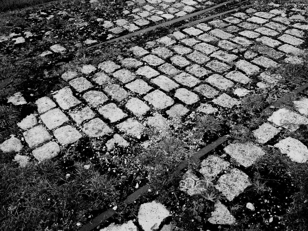 High angle view of abandoned railroad track on cobblestone