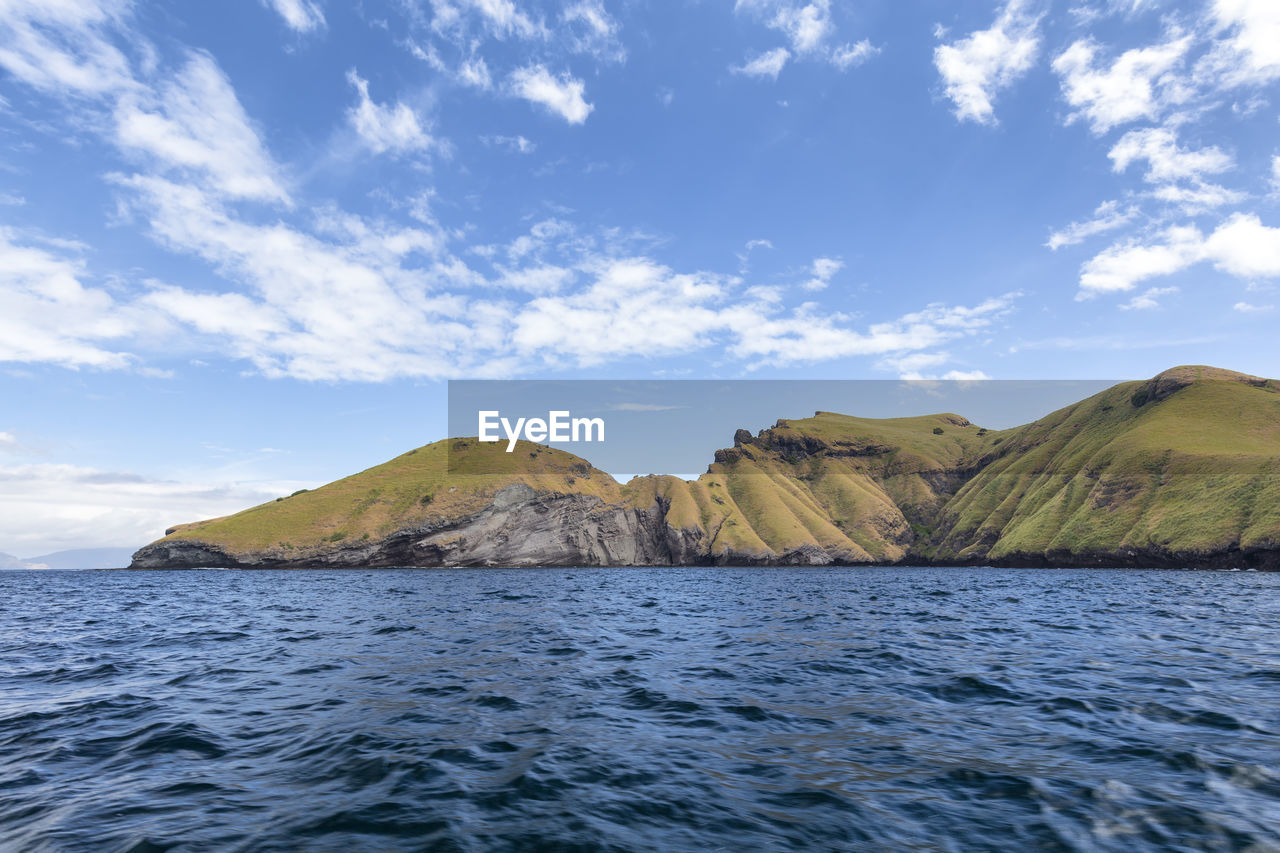 Scenic view of sea and mountains against sky