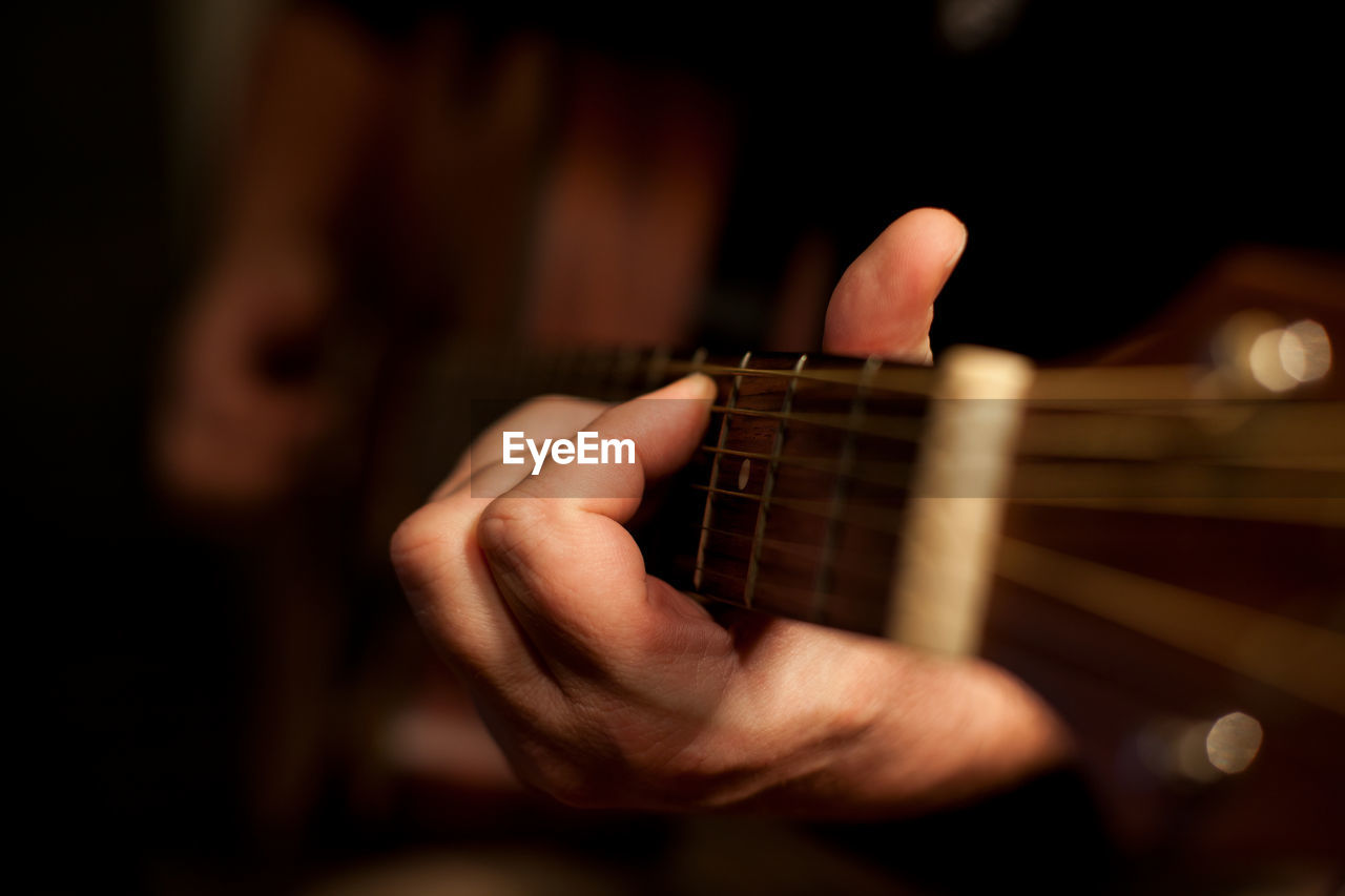 Close-up of man playing guitar