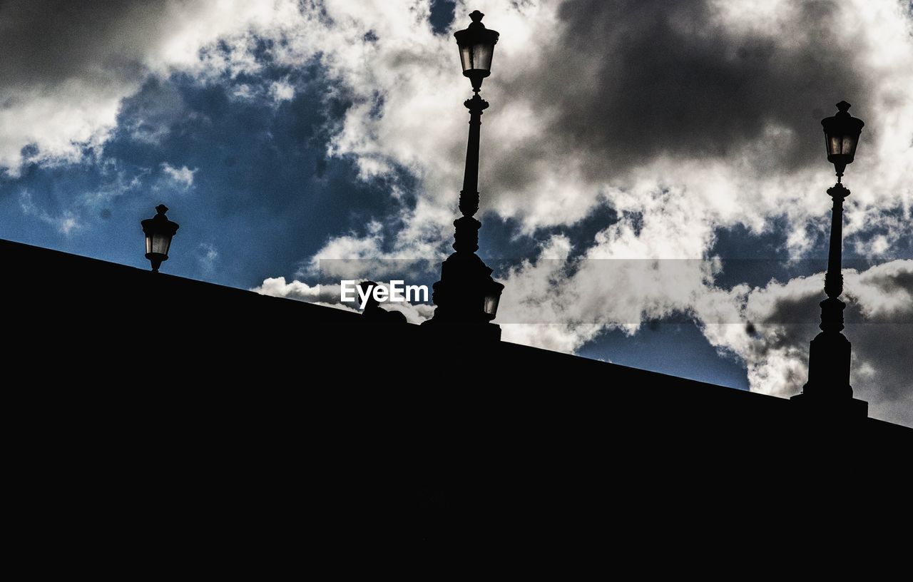 LOW ANGLE VIEW OF STREET LIGHT AGAINST CLOUDY SKY