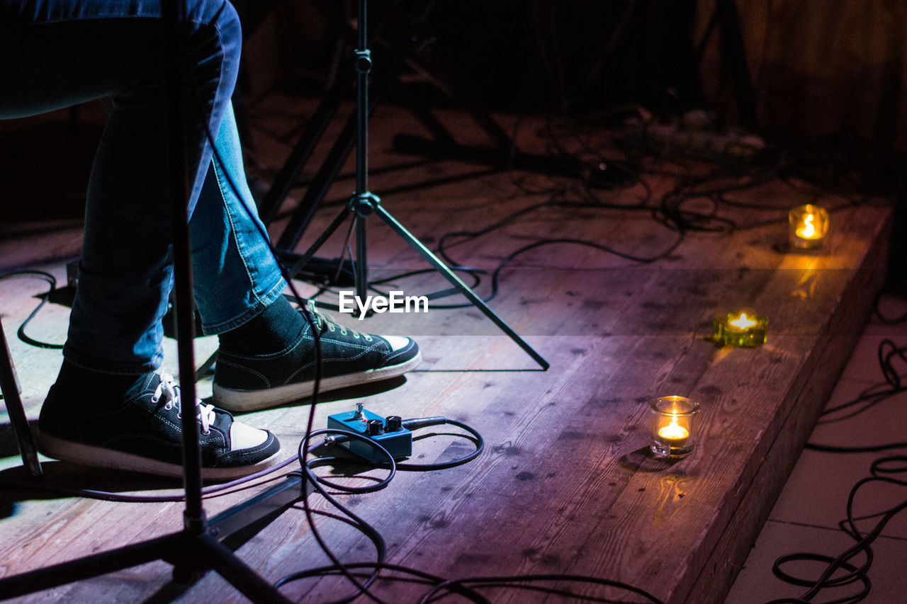 Low section of man photographing illuminated stage