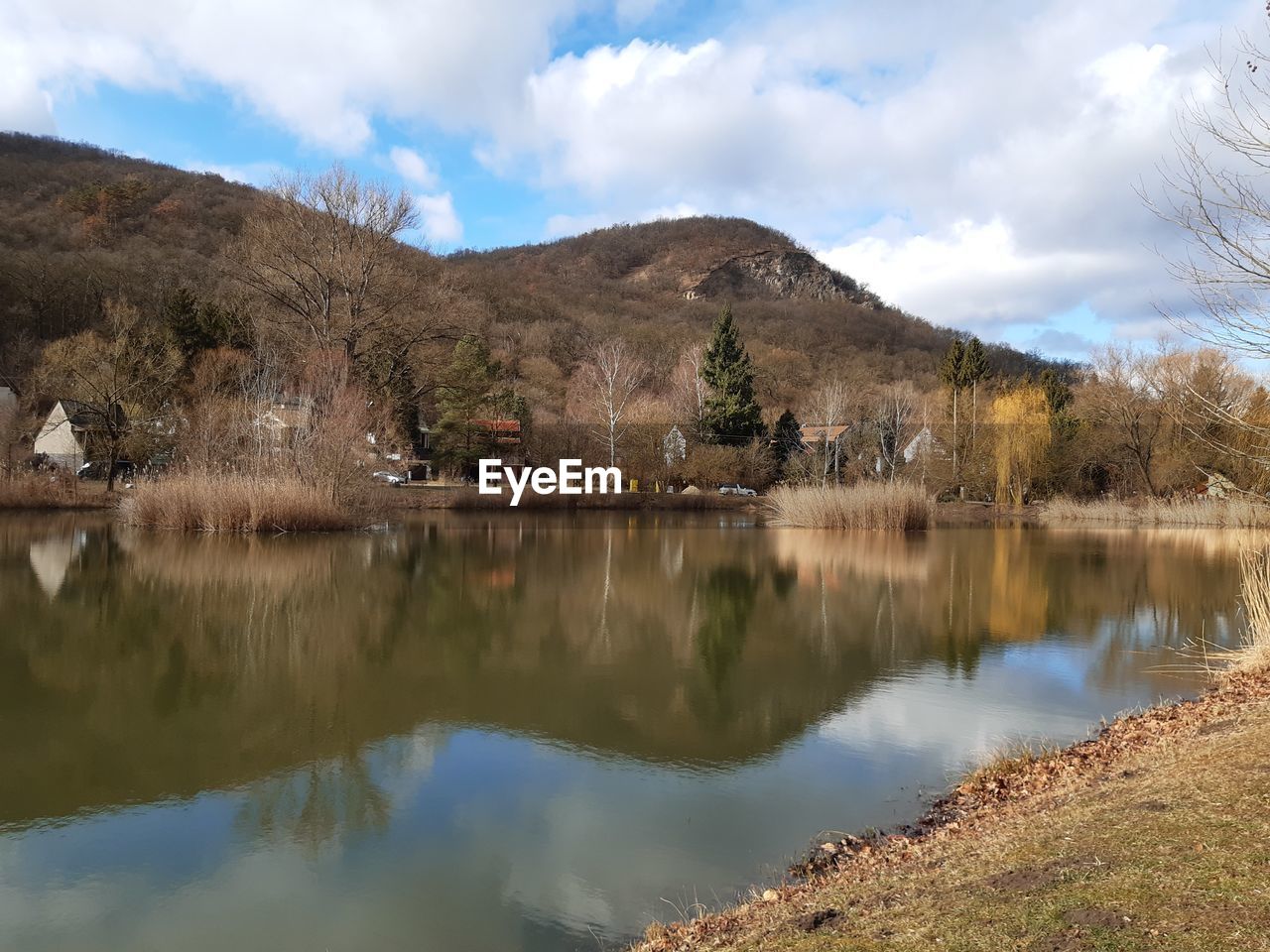 Scenic view of lake by mountains against sky