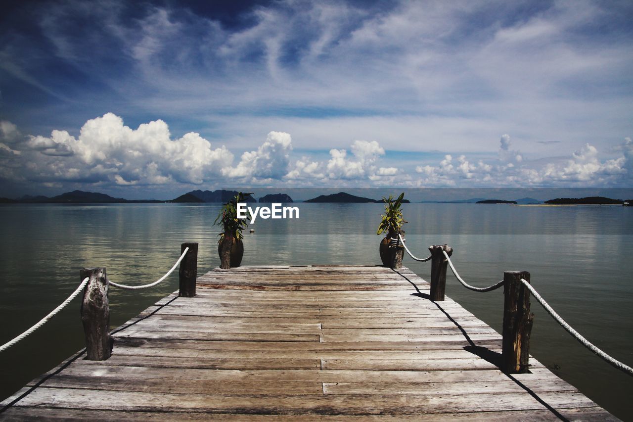 Wooden pier over sea against sky