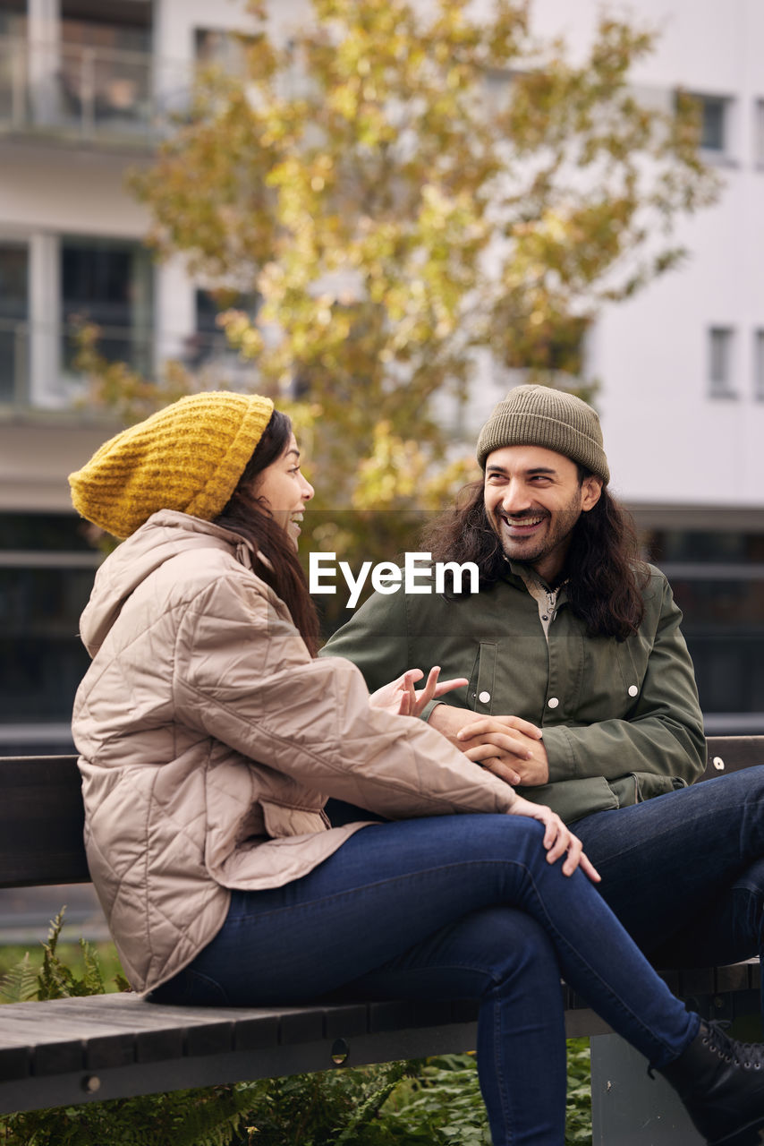 Man and woman talking on bench