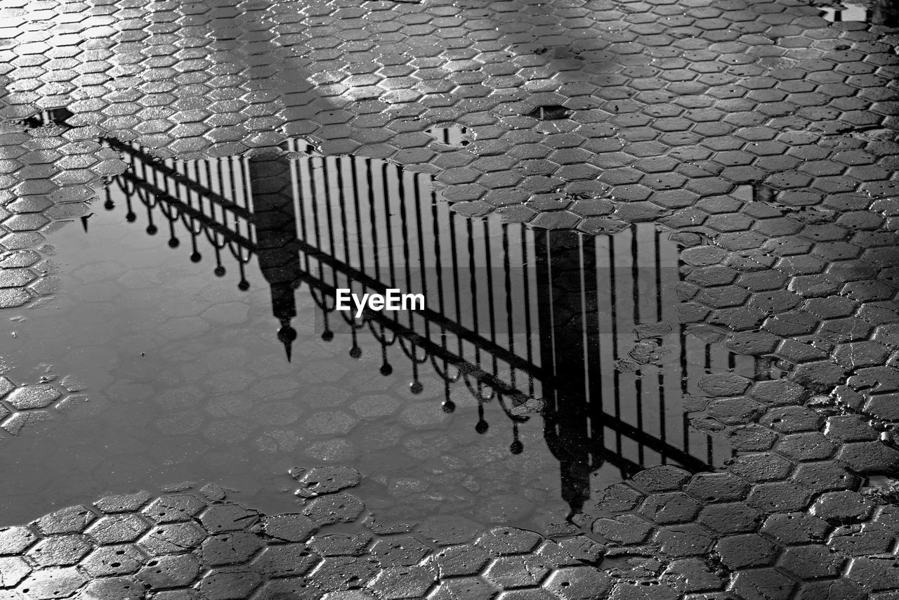 Reflection of railing on puddle