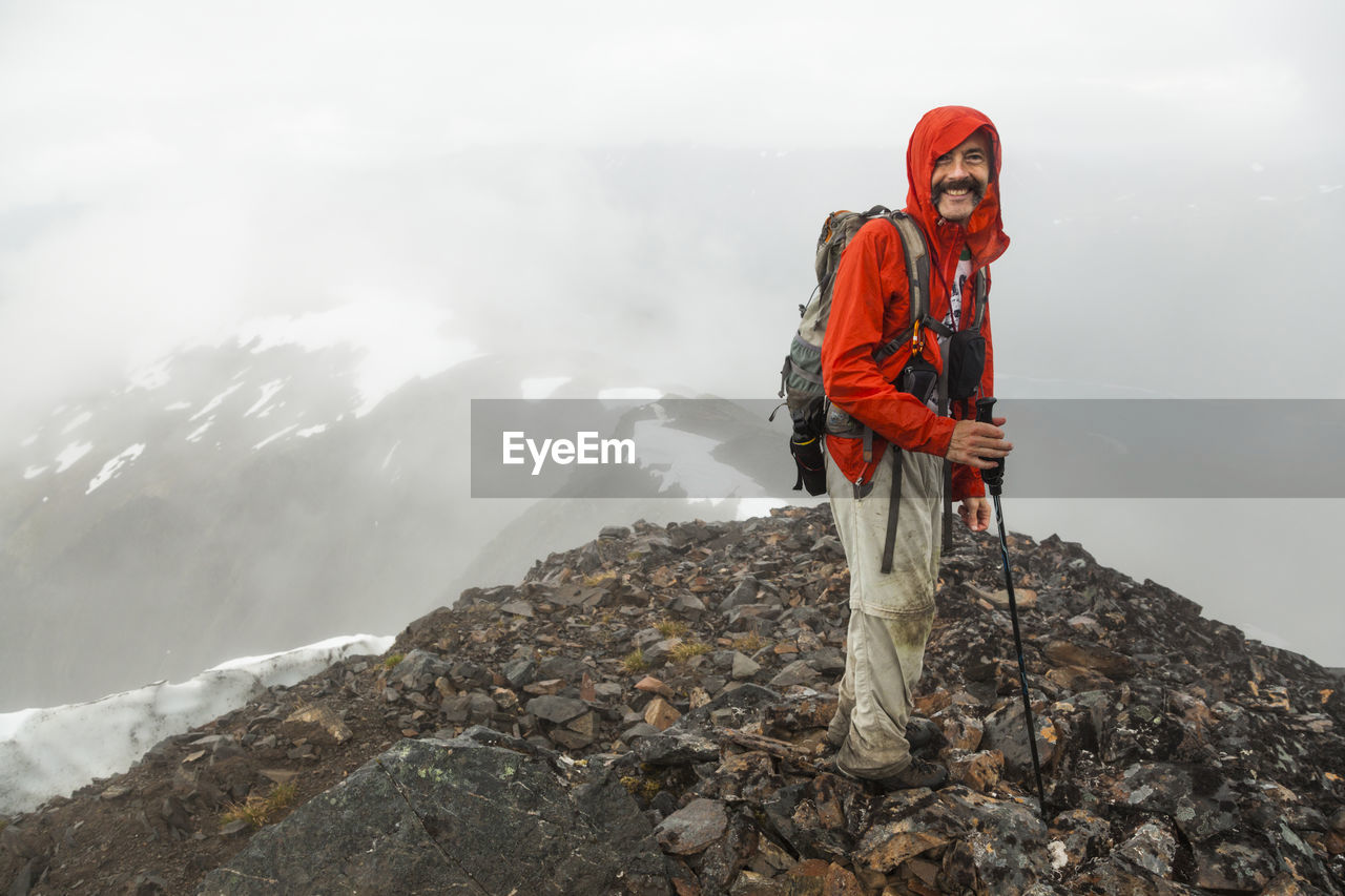 Man stands on summit of cooper mountain, kenai peninsula, alaska