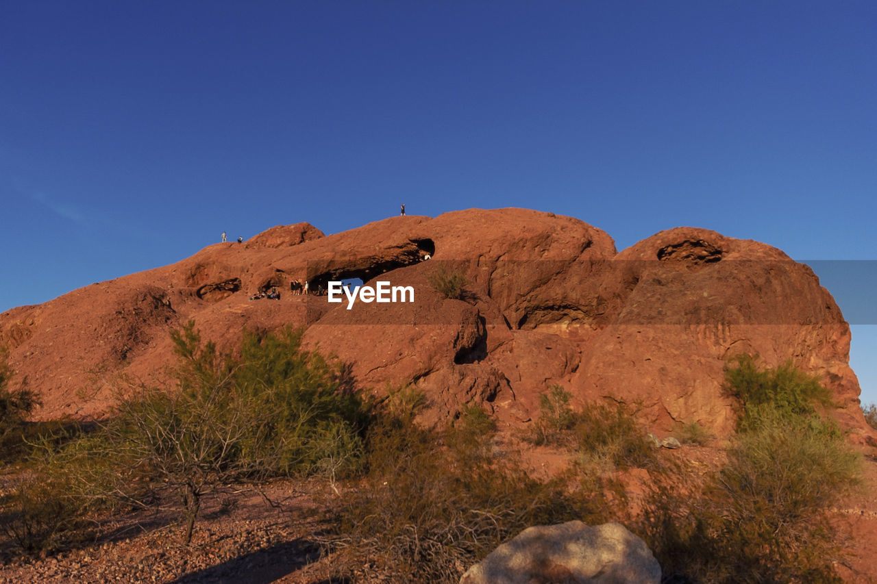 Low angle view of rock formation against clear blue sky
