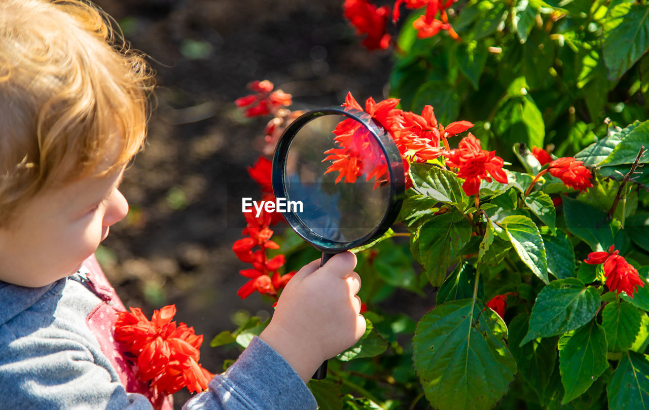 portrait of girl blowing bubbles against plants