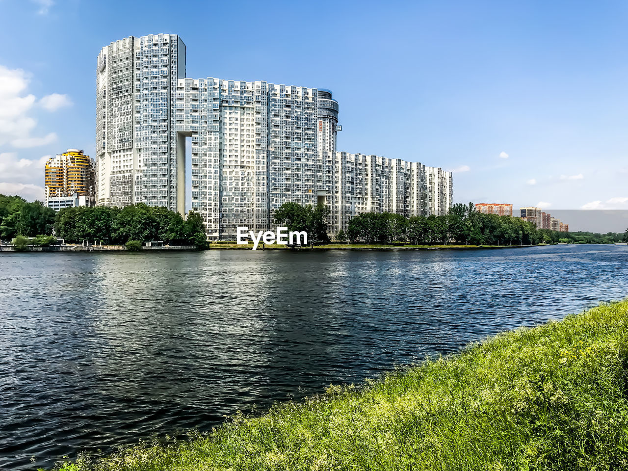 BUILDINGS BY RIVER AGAINST SKY