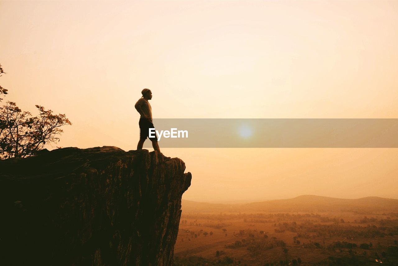 Silhouette of man on cliff