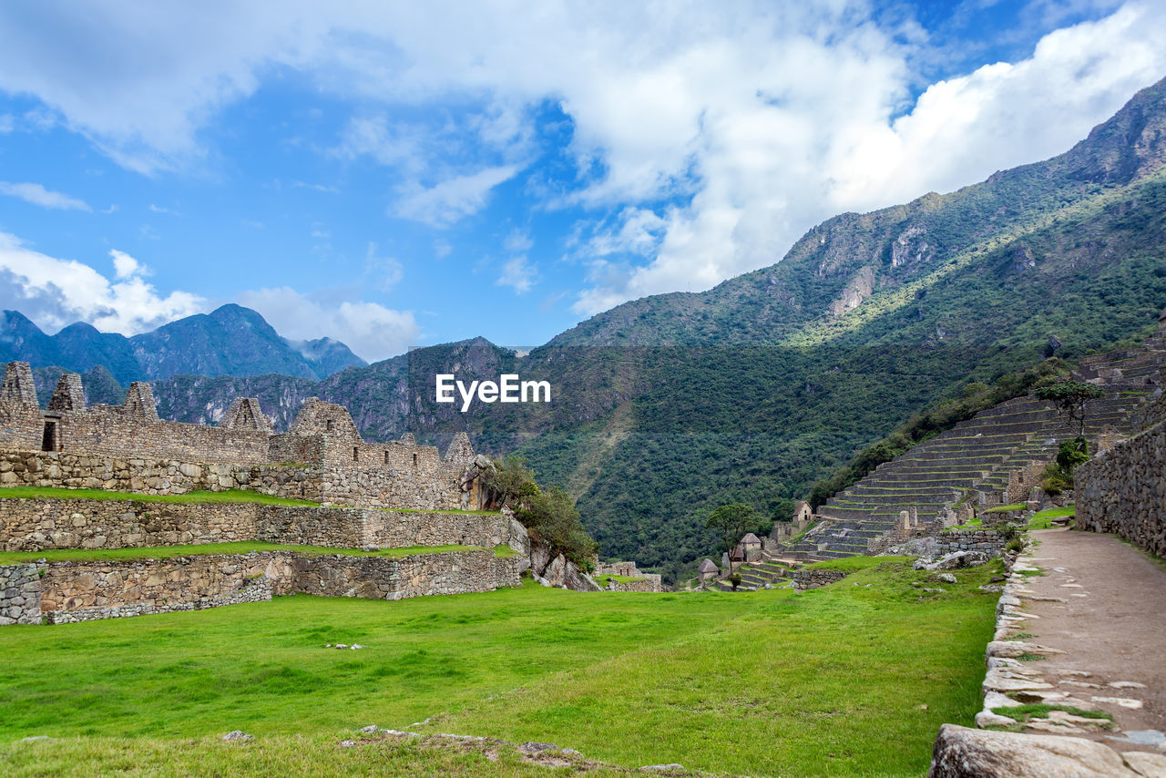 Old ruins at machu picchu by mountains against sky