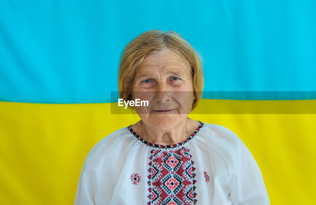 Portrait of senior woman in front of ukrainian flag