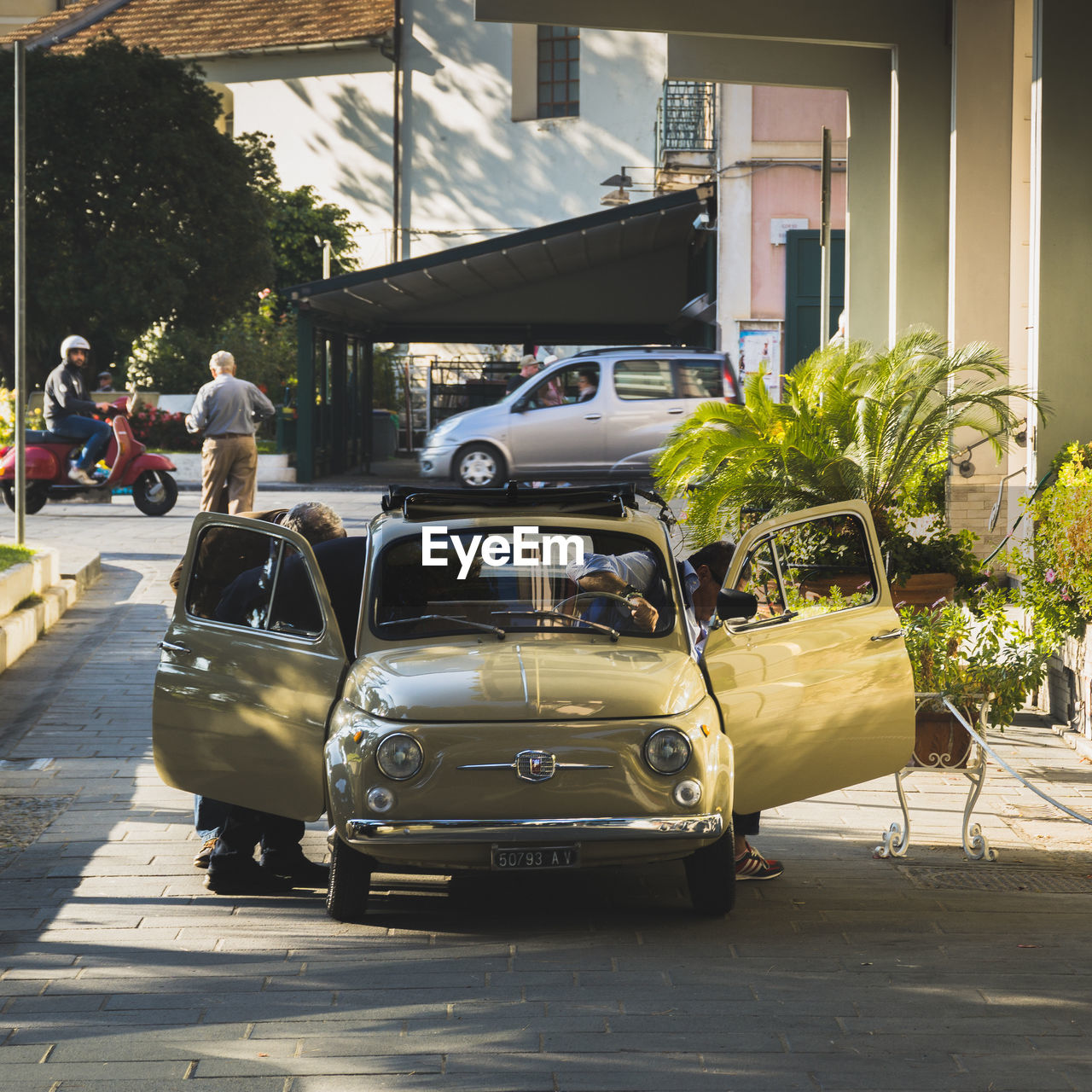 PEOPLE IN CAR ON CITY