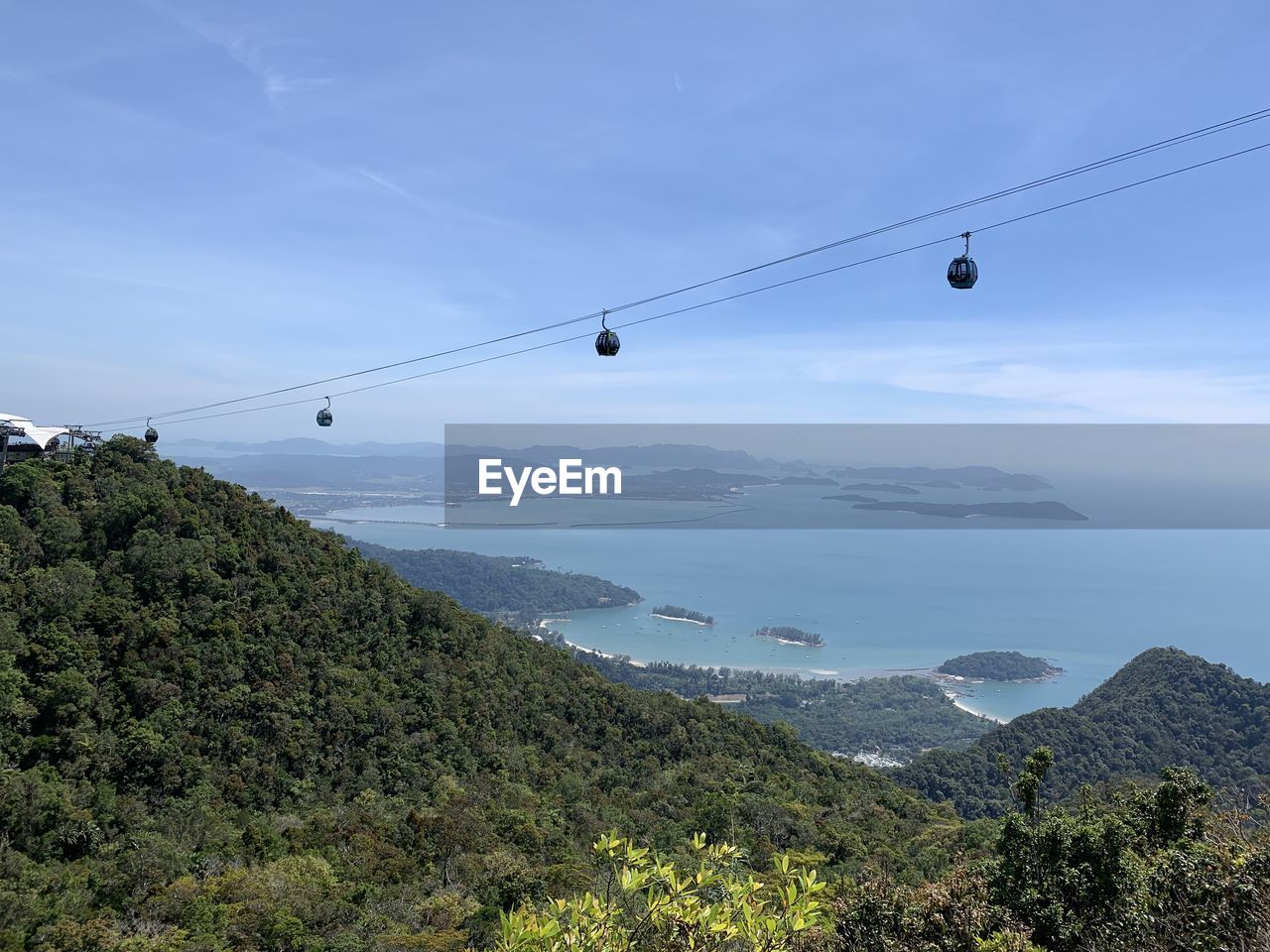 Overhead cable car over mountains against sky