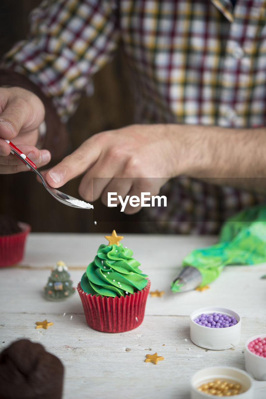 CROPPED IMAGE OF HAND HOLDING CAKE