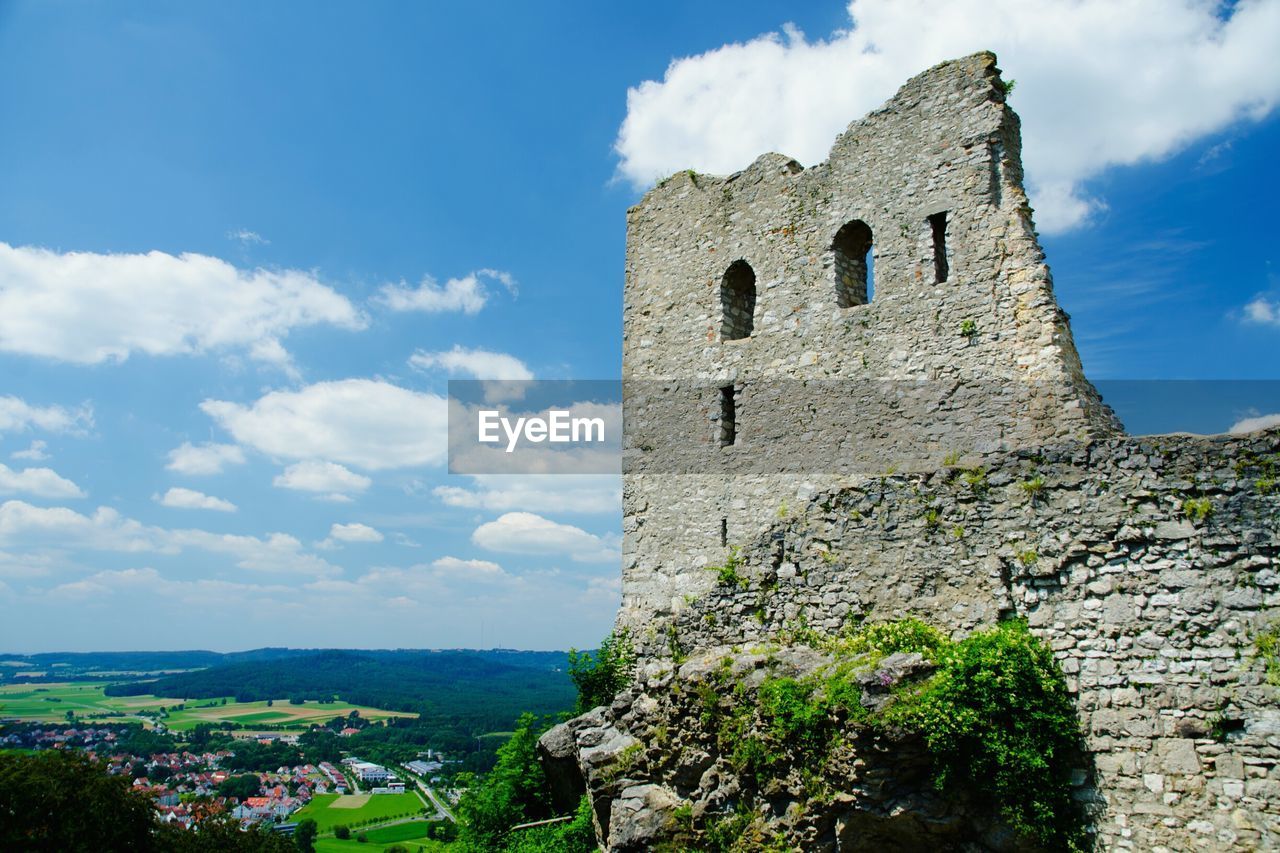 Old ruins by landscape against sky