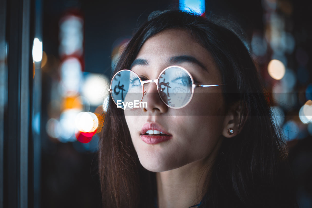 CLOSE-UP PORTRAIT OF YOUNG WOMAN WITH EYEGLASSES